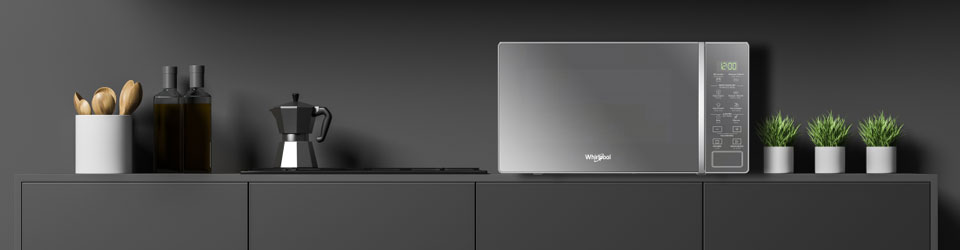 Horno microondas Whirlpool 7501545507533 ambientada en cocina negra bien integrado al estilo interior gracias a su diseño tipo espejo en su superficie frontal y el color gris con negro.